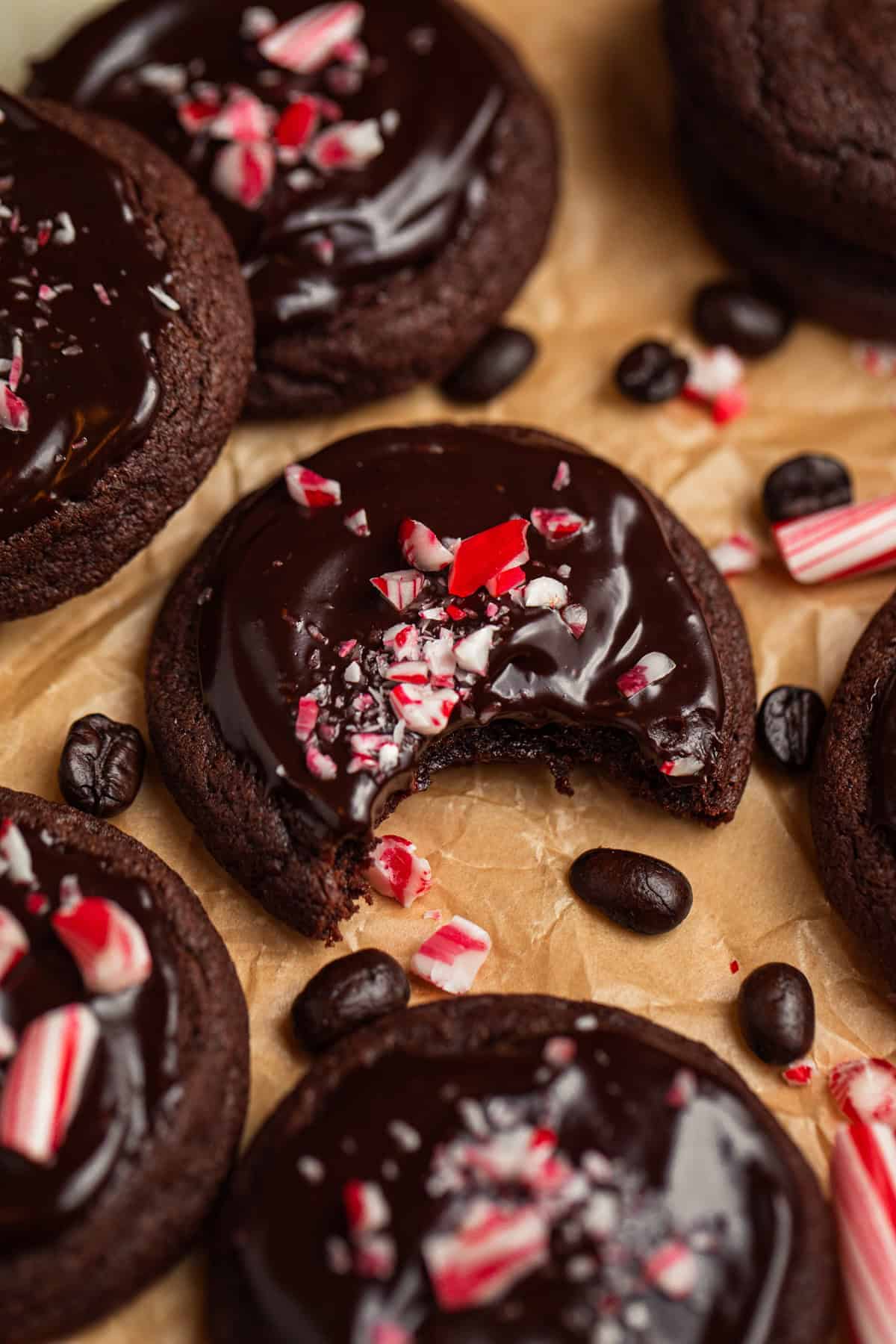 Peppermint mocha cookies on parchment with espresso beans and crushed peppermint candy.