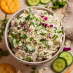 Bowl with feta chicken salad topped with fresh dill and parsley.