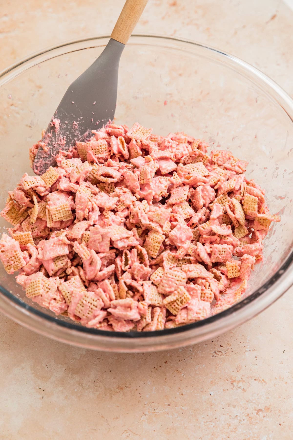 Strawberry chex mix in bowl with spoon.