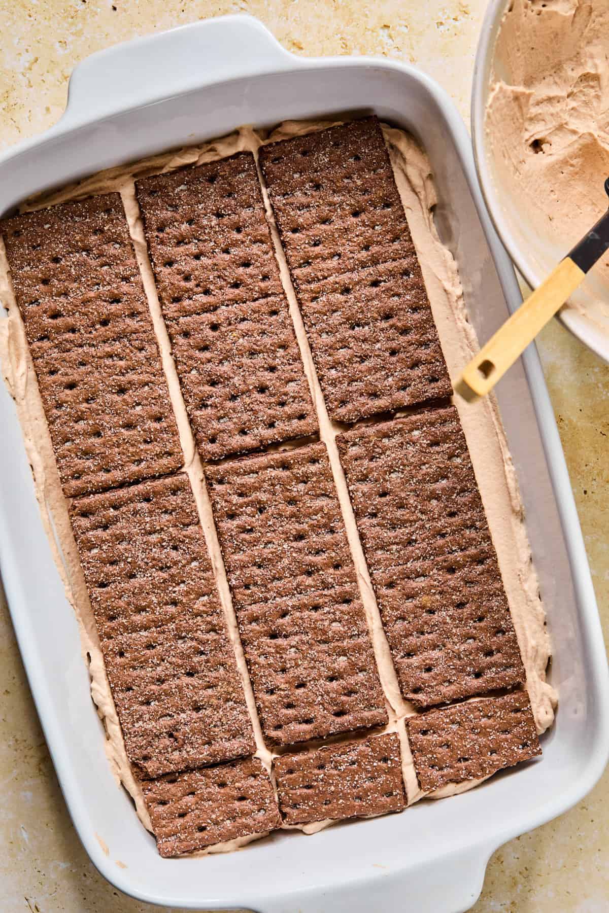 Chocolate graham crackers layered over chocolate cream.