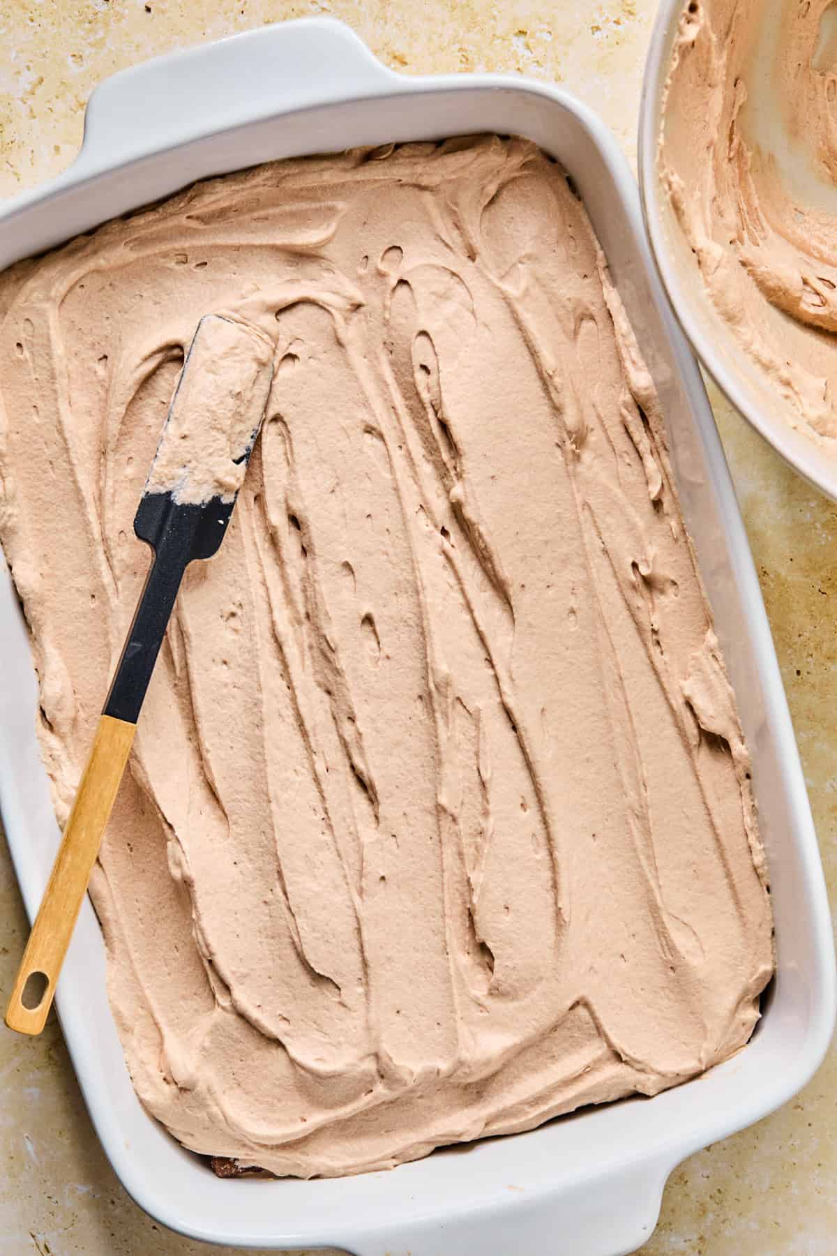 Chocolate whipped cream spread over top of grahams in pan.