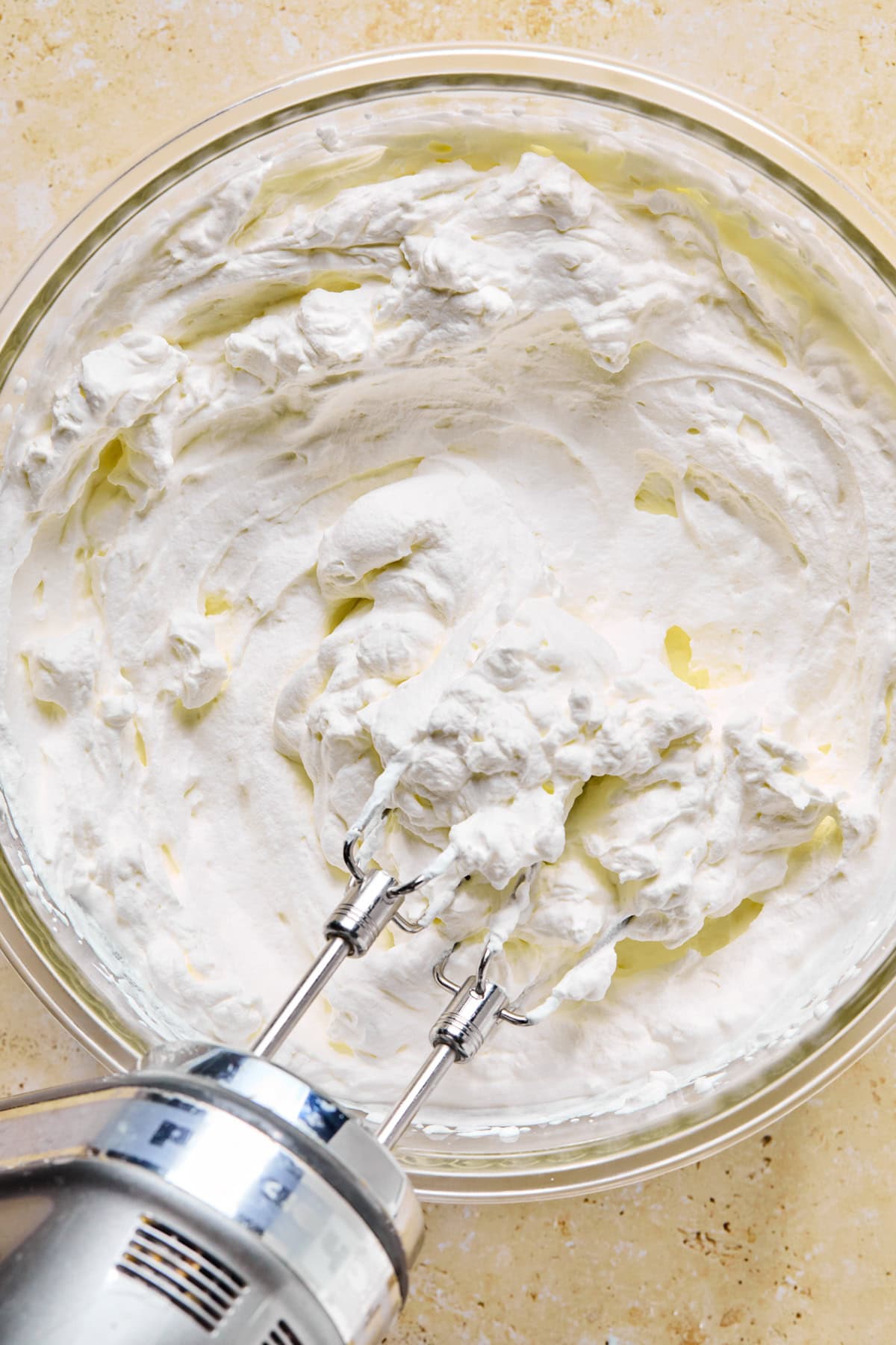 Heavy cream whipped into whipped cream in bowl.