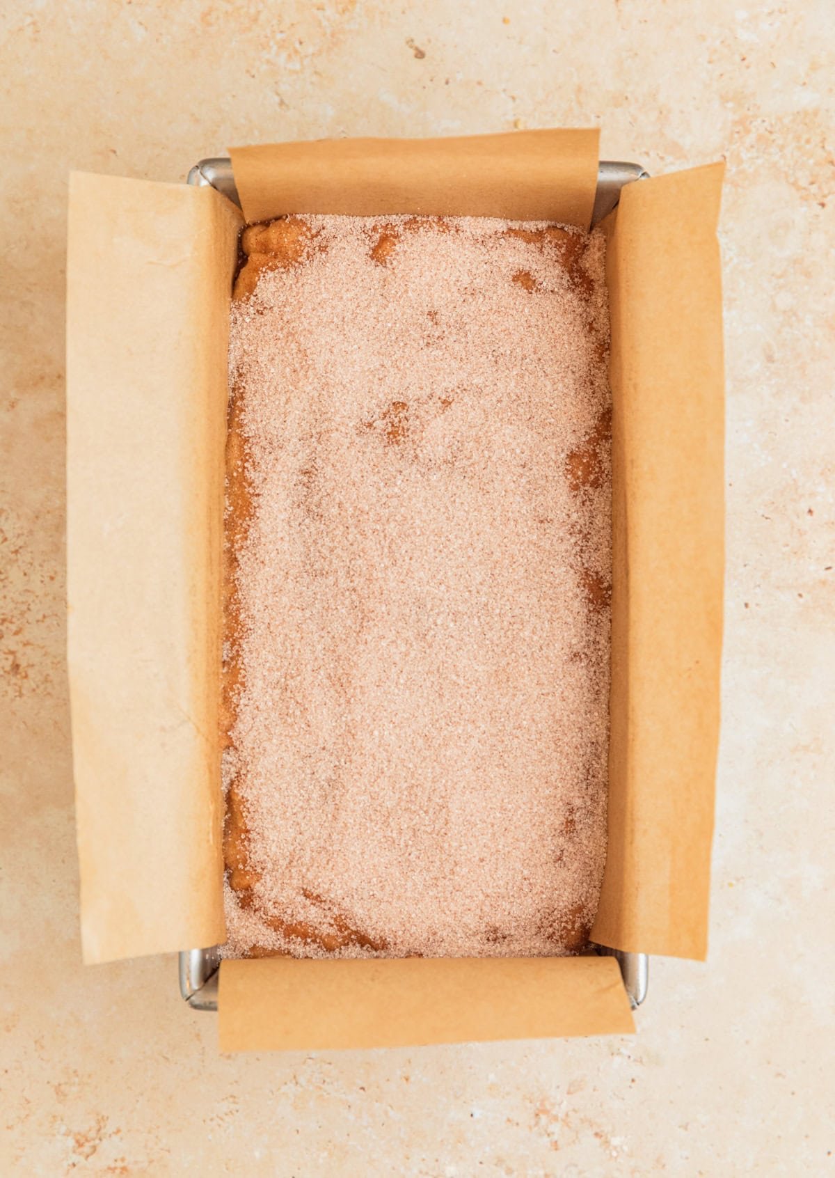 Cinnamon sugar topping poured over banana bread before baking.