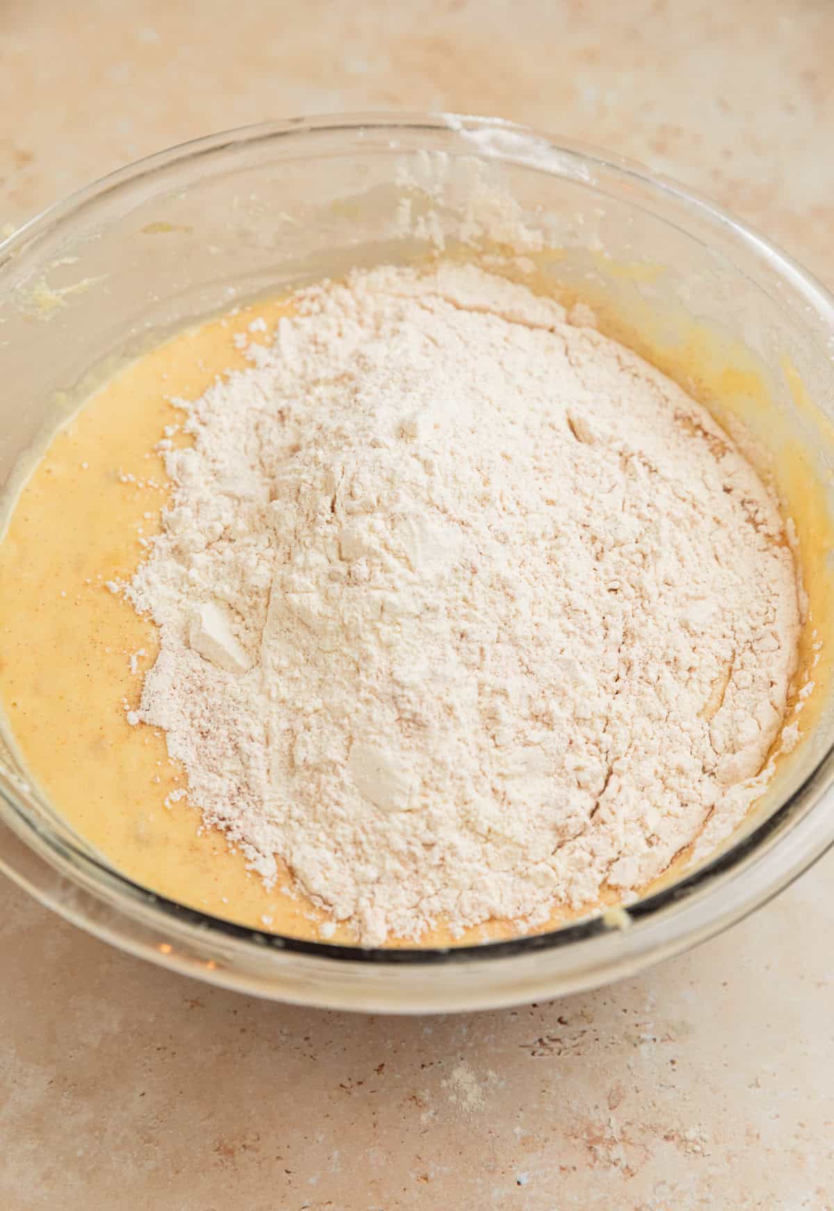 Dry ingredients added to wet ingredients in bowl.q