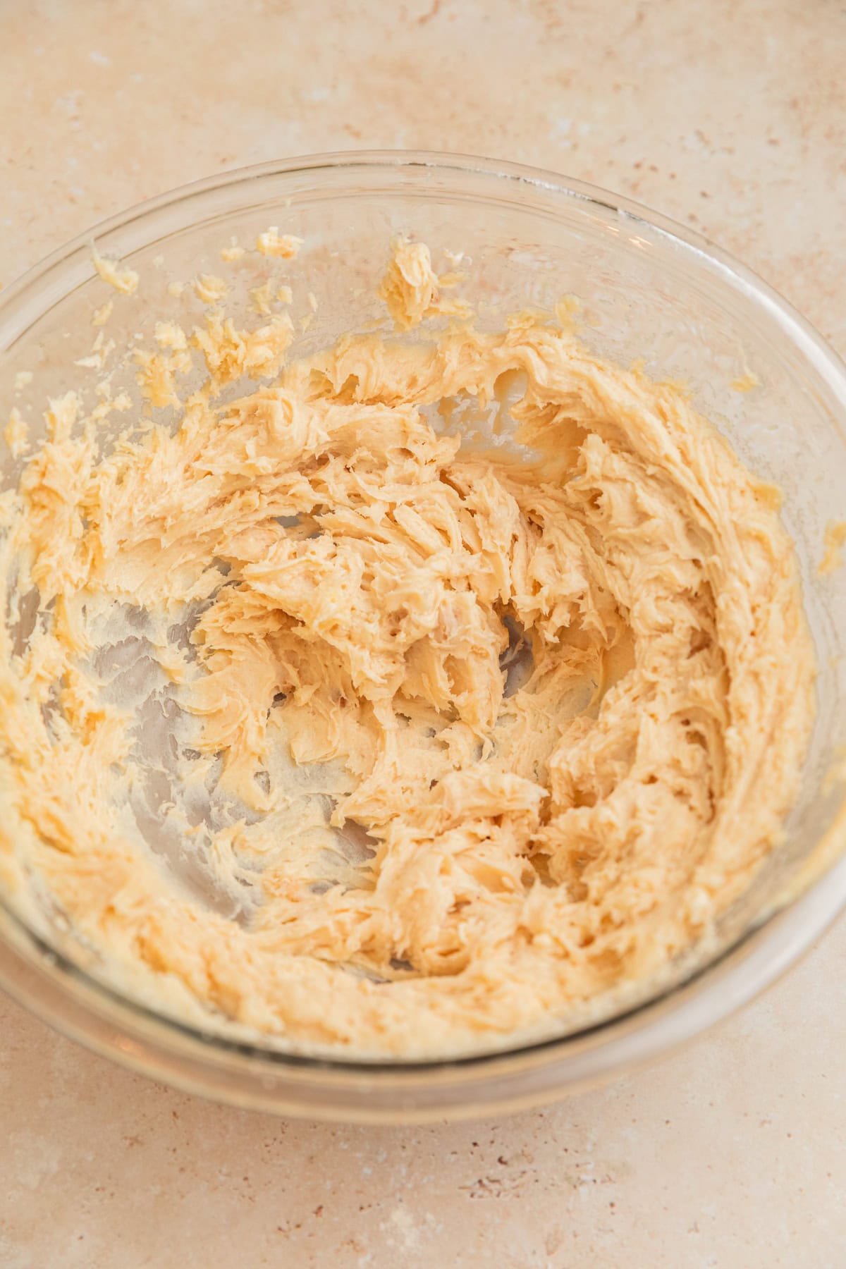 Creamed butter, sugars and cream cheese in glass mixing bowl.