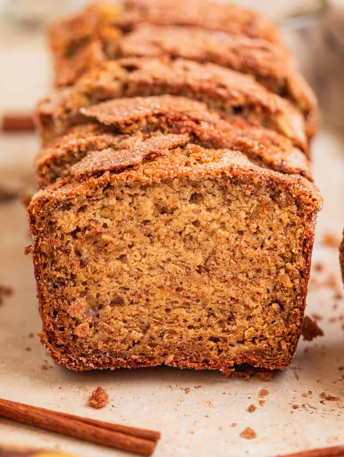 Cinnamon sugar topped banana bread sliced and propped up in a row.