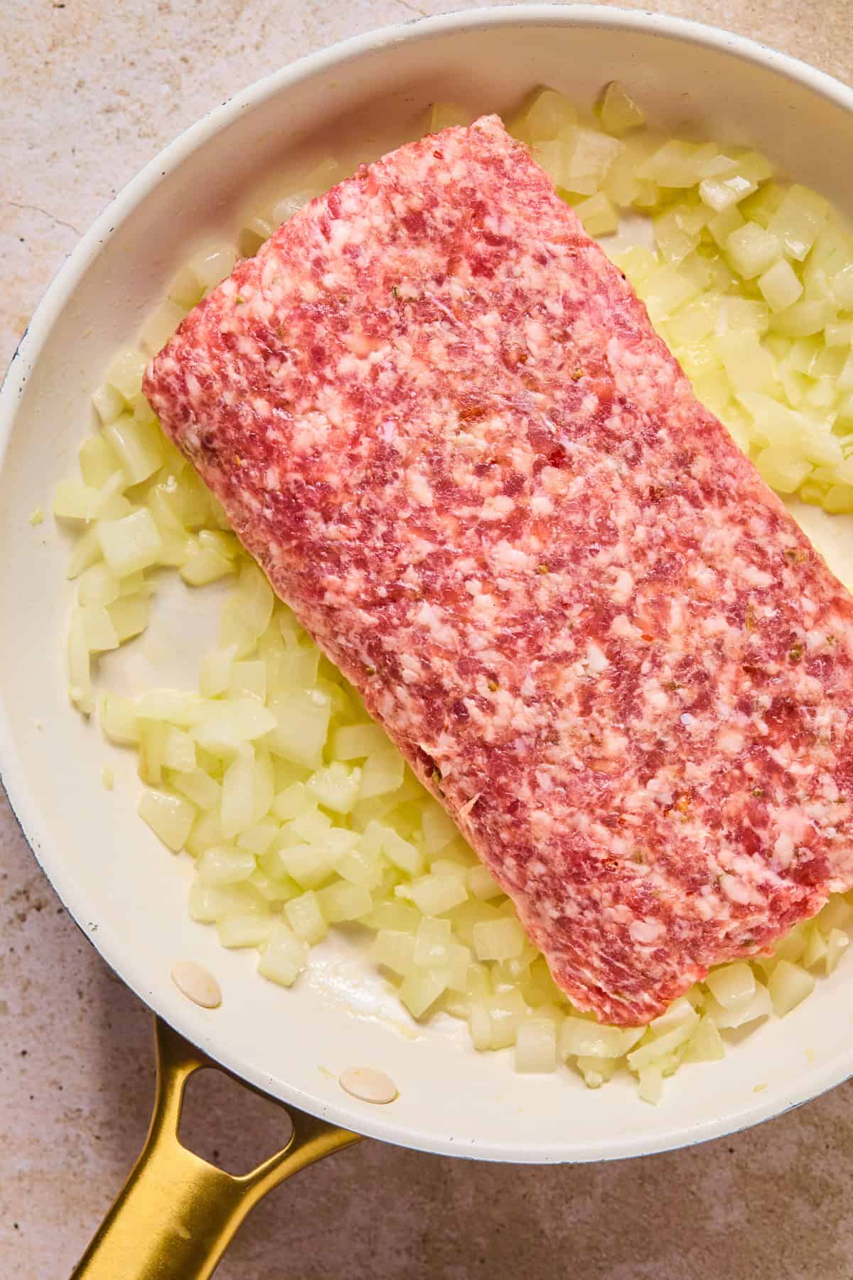 Sautéed onions with Italian sausage added to skillet.