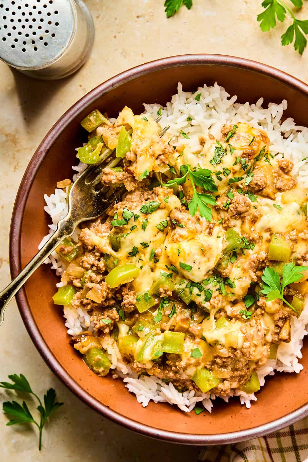 Philly cheesesteak rice bowl with fork propped in.