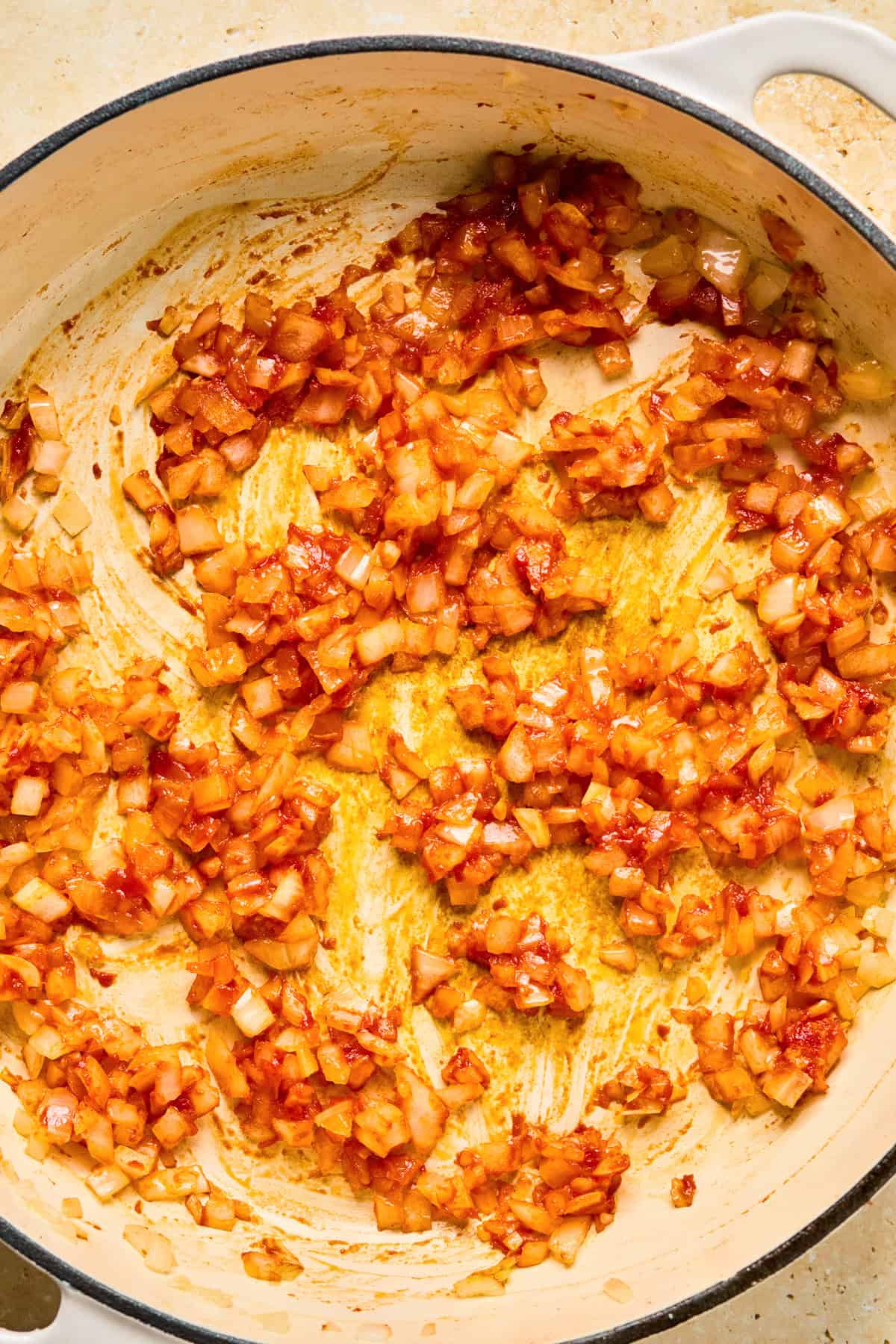 Tomato paste and onion in pan.