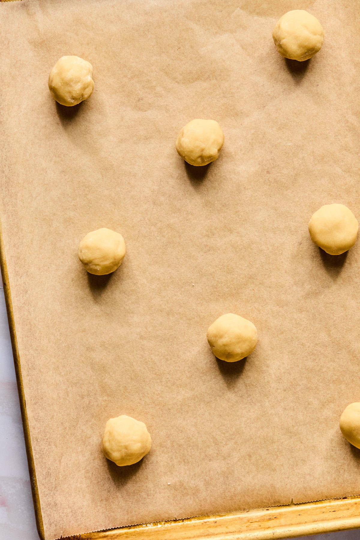 Sugar cookie dough on parchment lined cookie sheet.