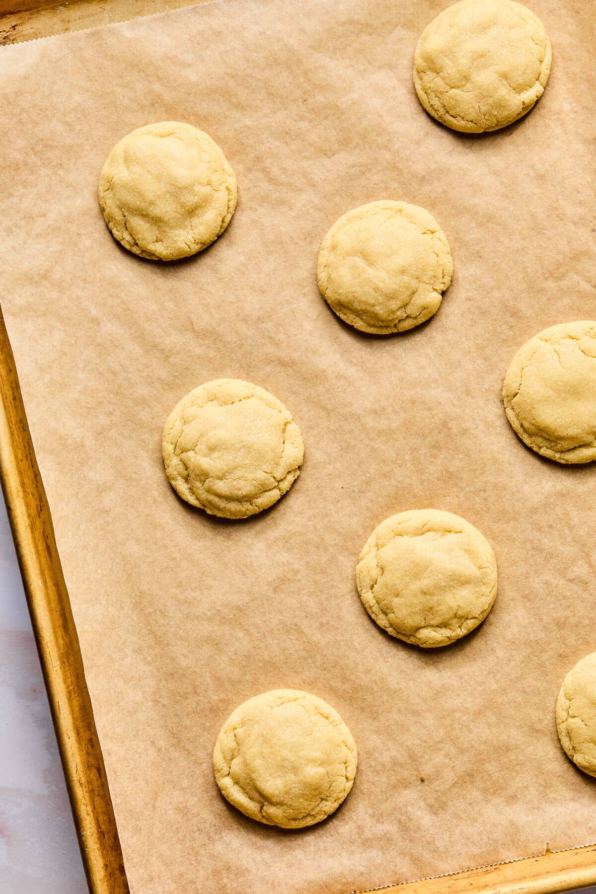 Baked sugar cookies on baking sheet.