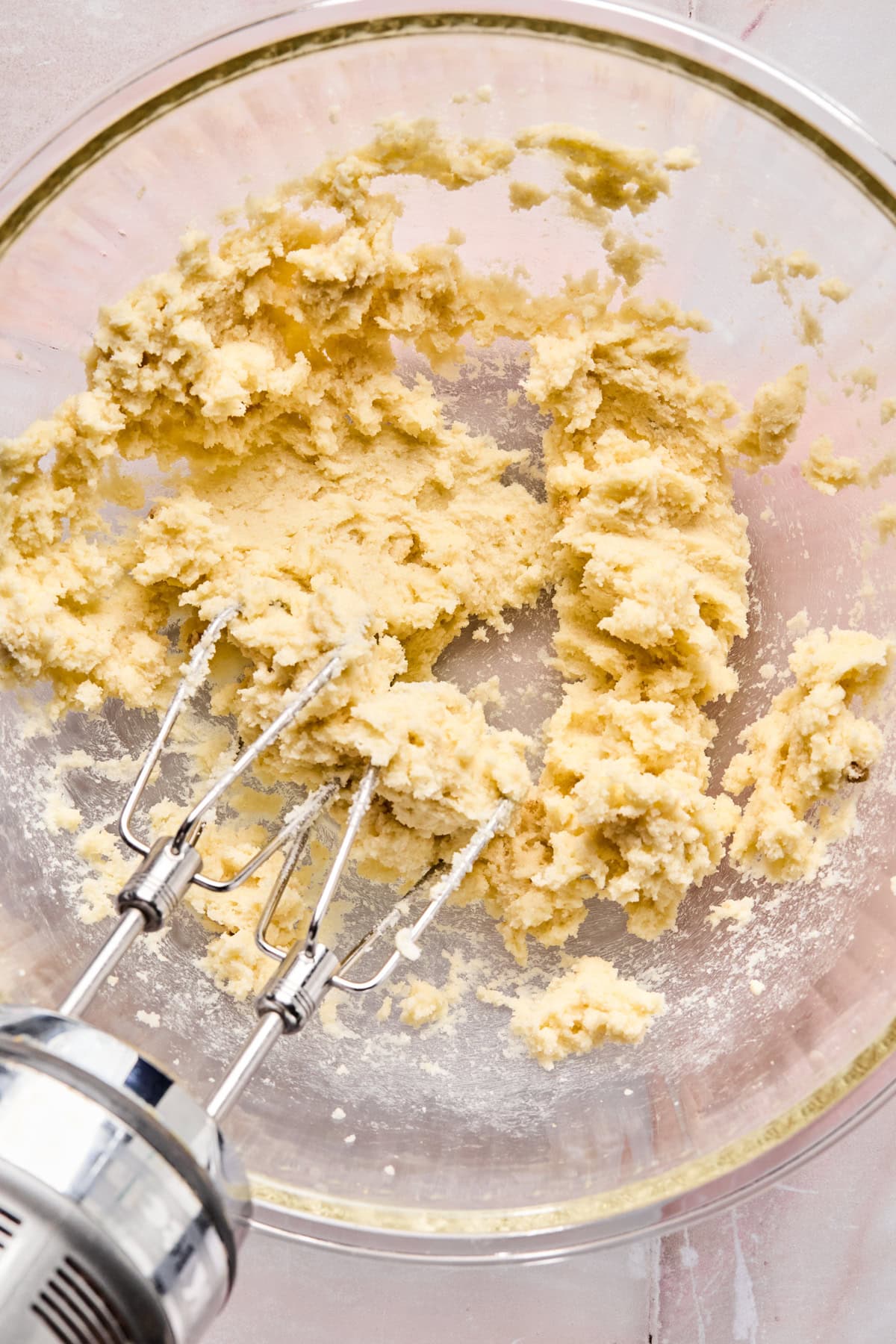 Butter and sugars creamed in glass mixing bowl.