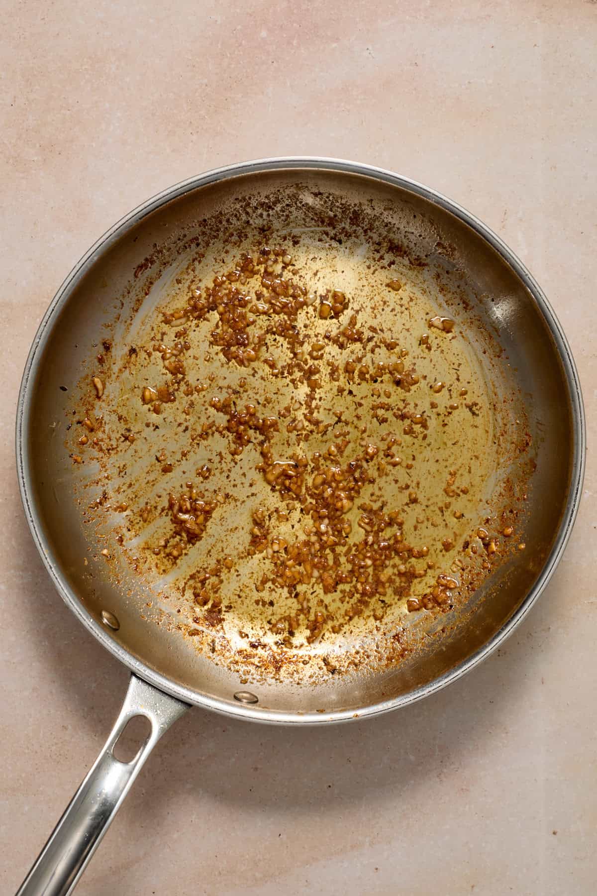 Skillet with garlic being sautéd.