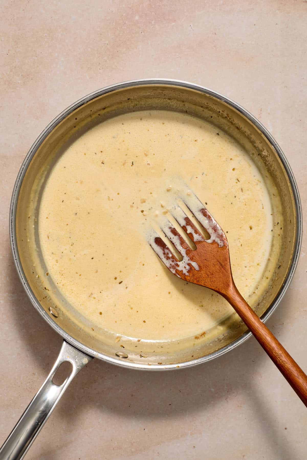 Cream cheese and cream added to pan with spatula.