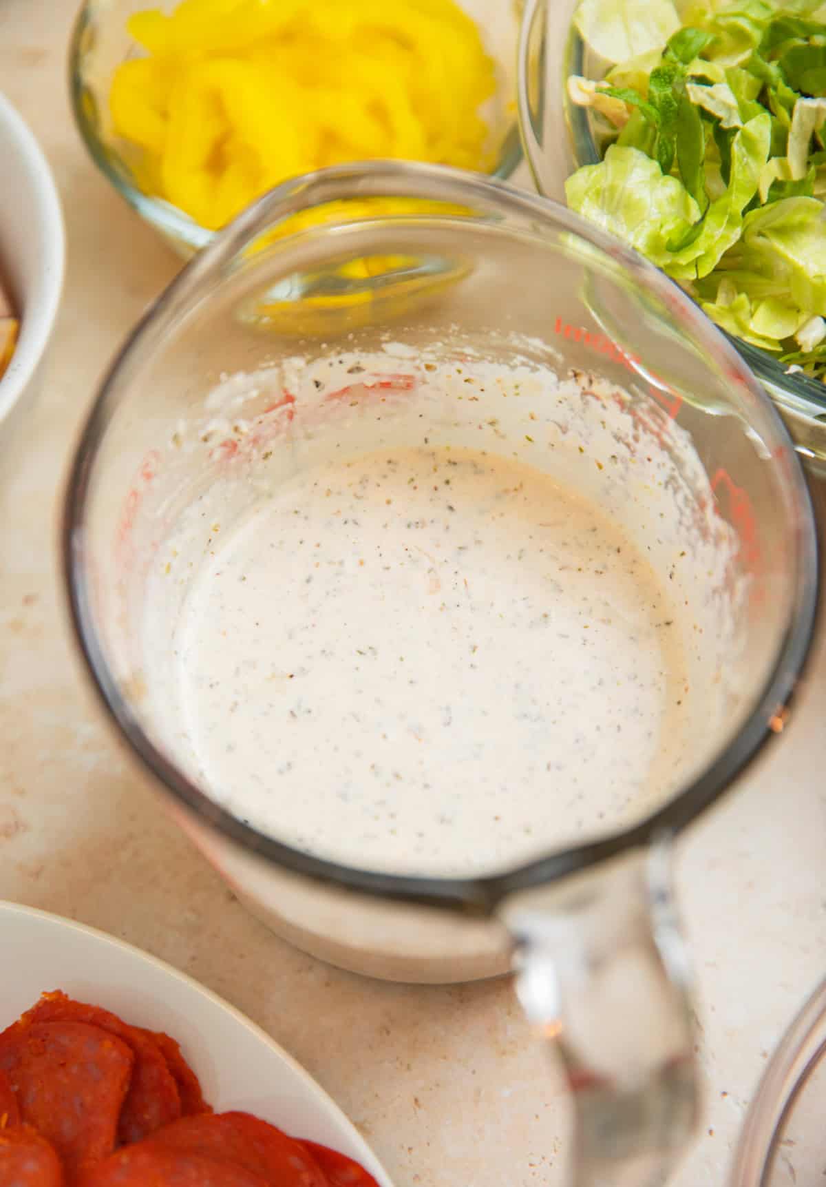 Creamy parmesan dressing mixed in mixing cup.