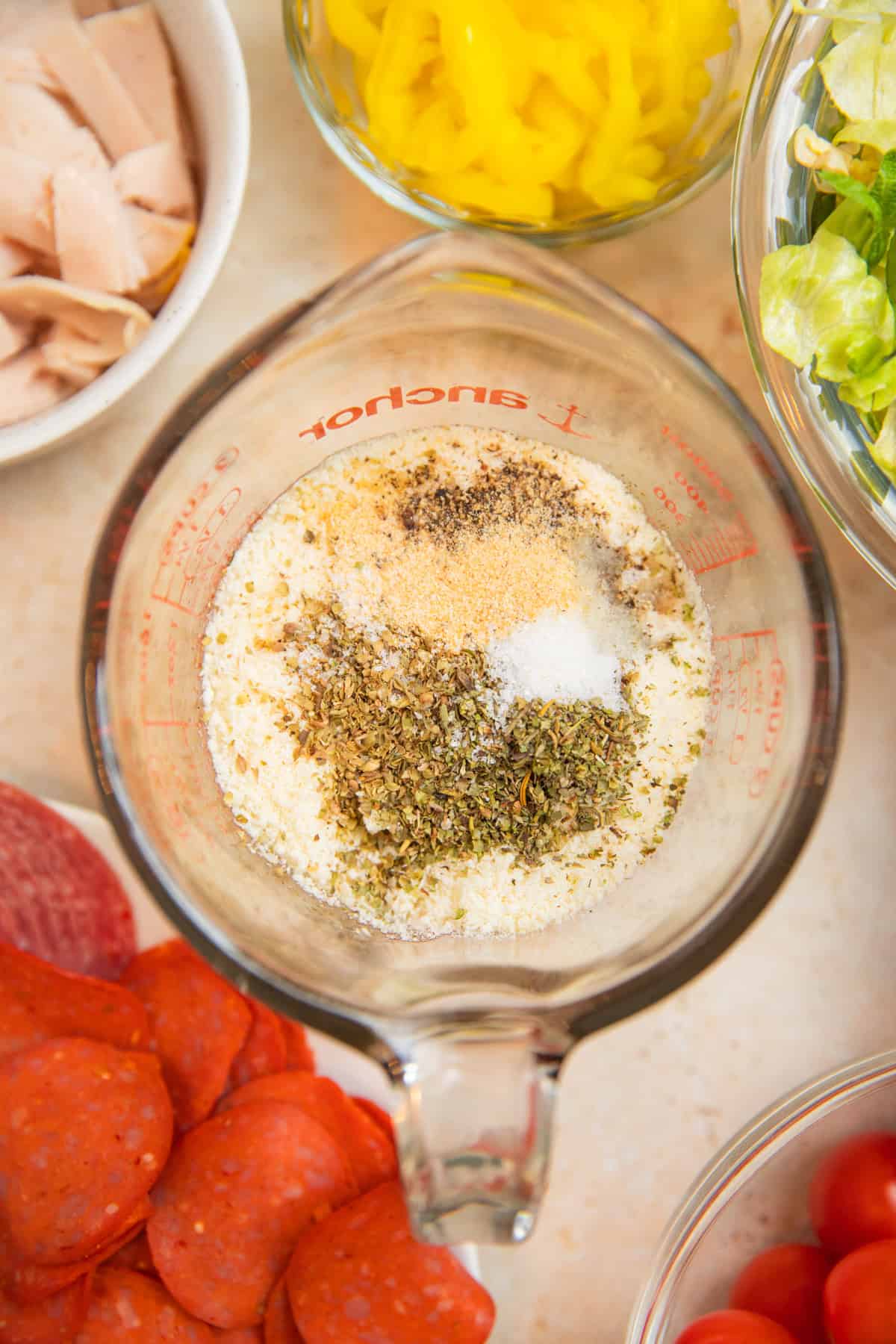 Mayonnaise, red wine vinegar, parmesan and seasoning in measuring cup.