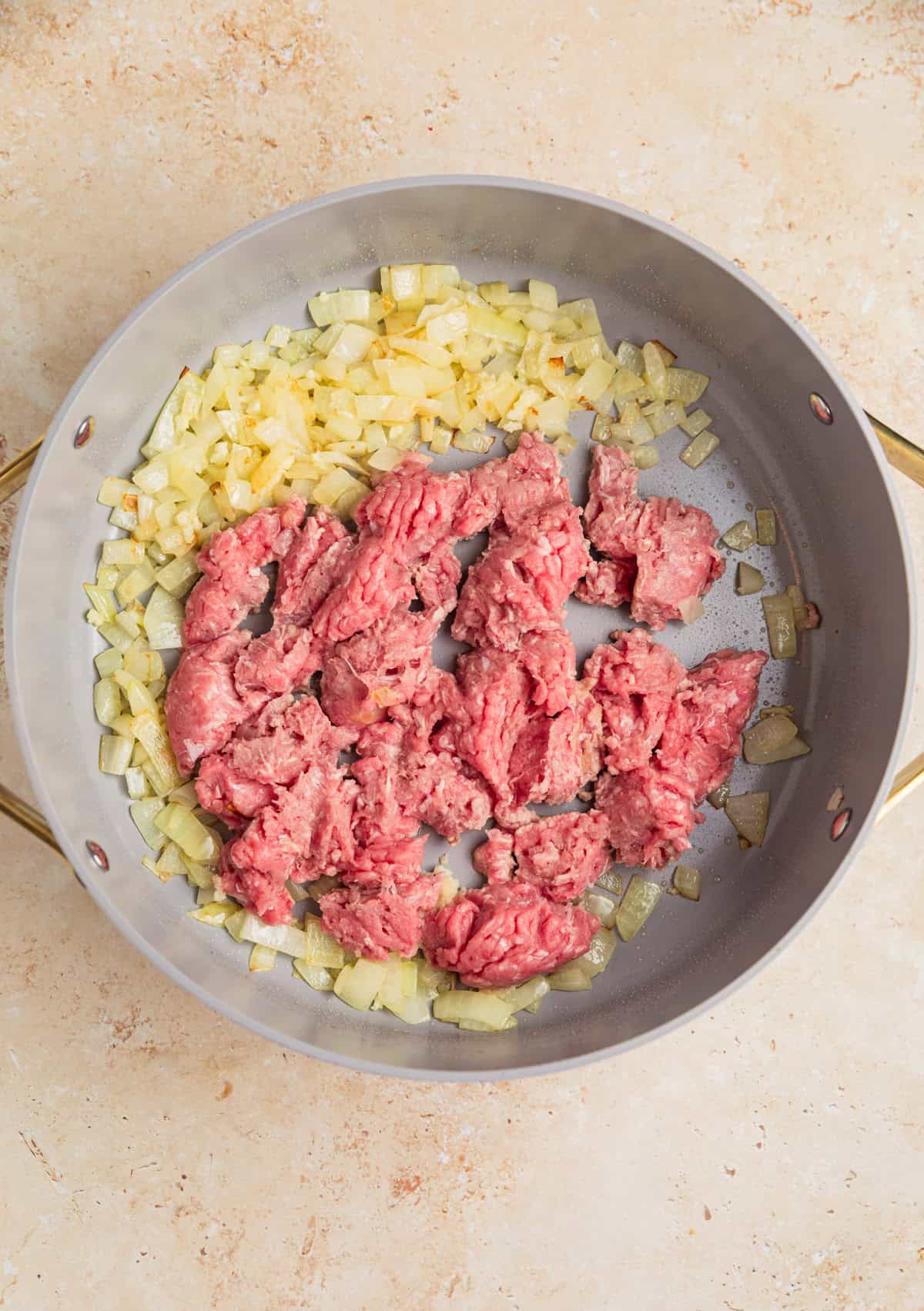 Ground turkey and onions browning in skillet.