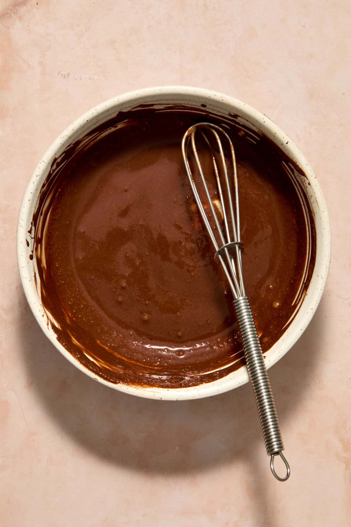 Cocoa powder and water whisked in small bowl with whisk.
