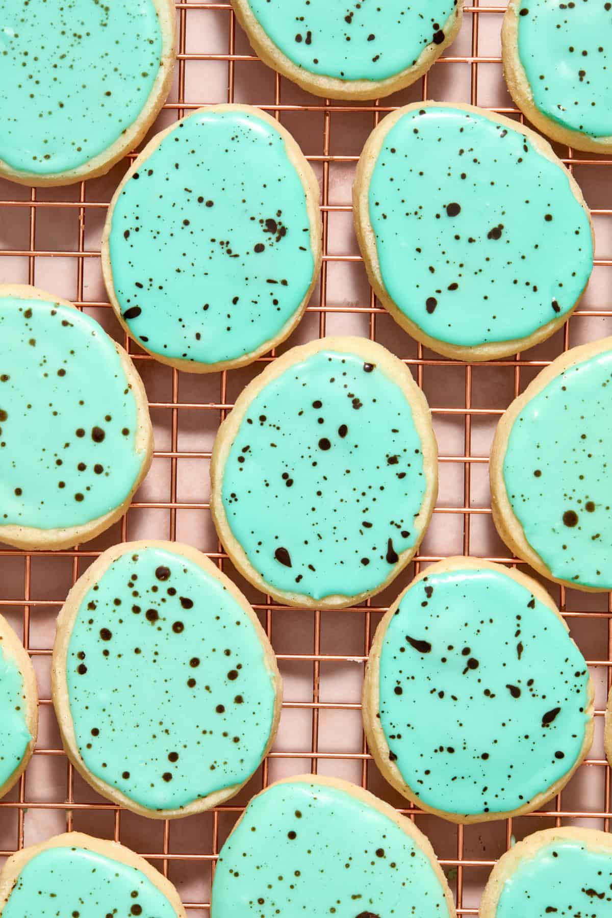 Speckled robin egg cookies on cooling rack.