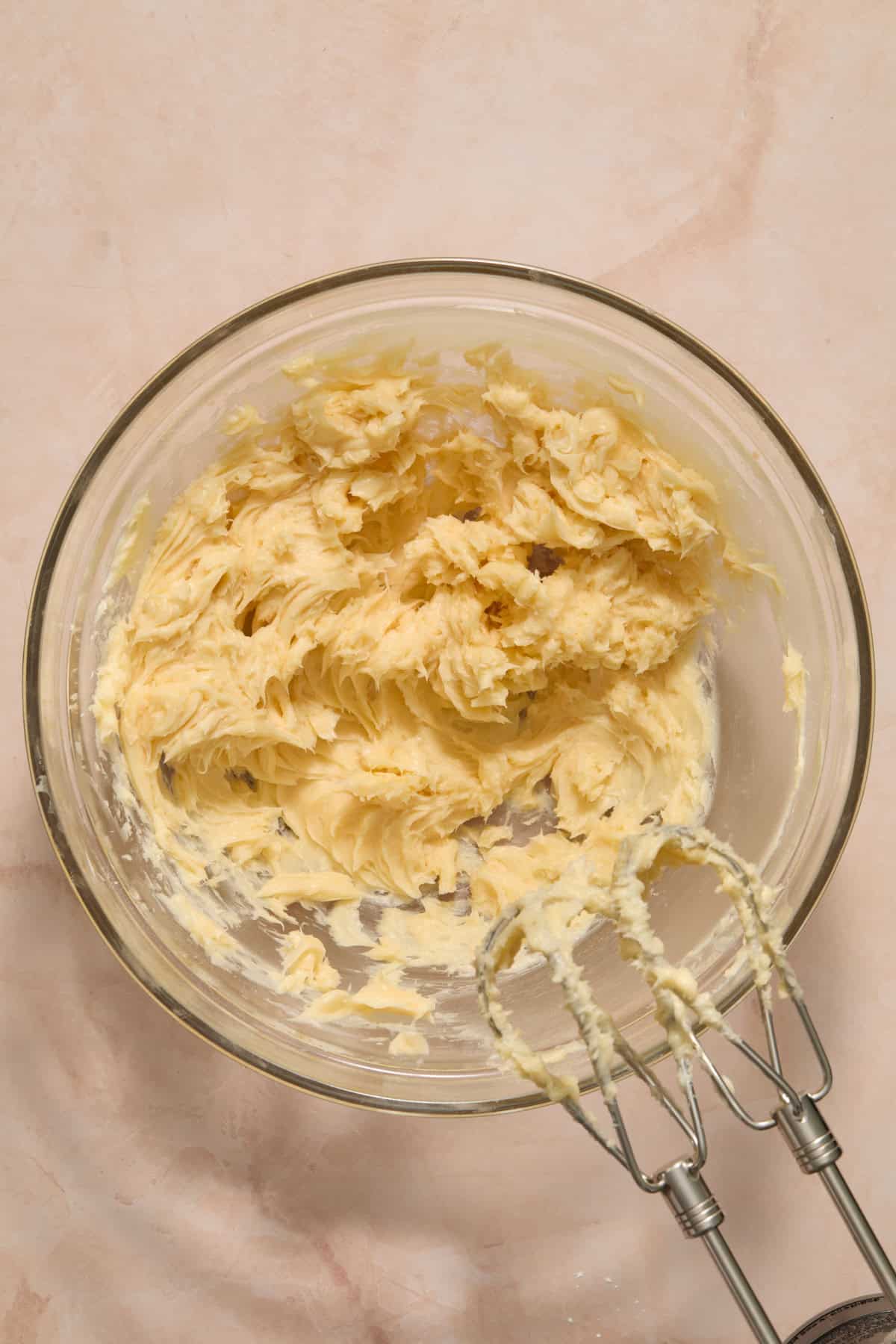 Bowl with creamed butter, vanilla and powdered sugar.