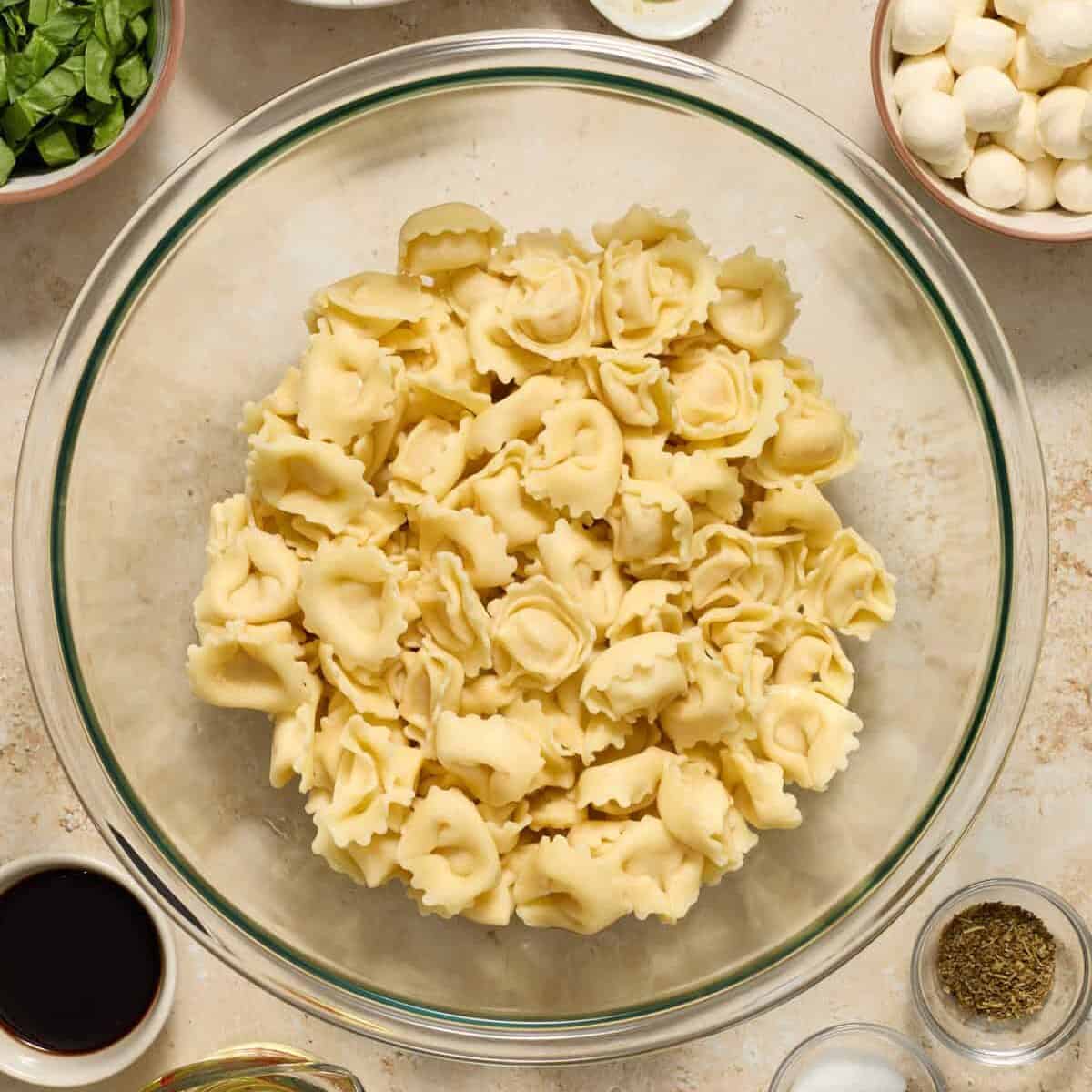 Cooked cheese tortellini in glass bowl.