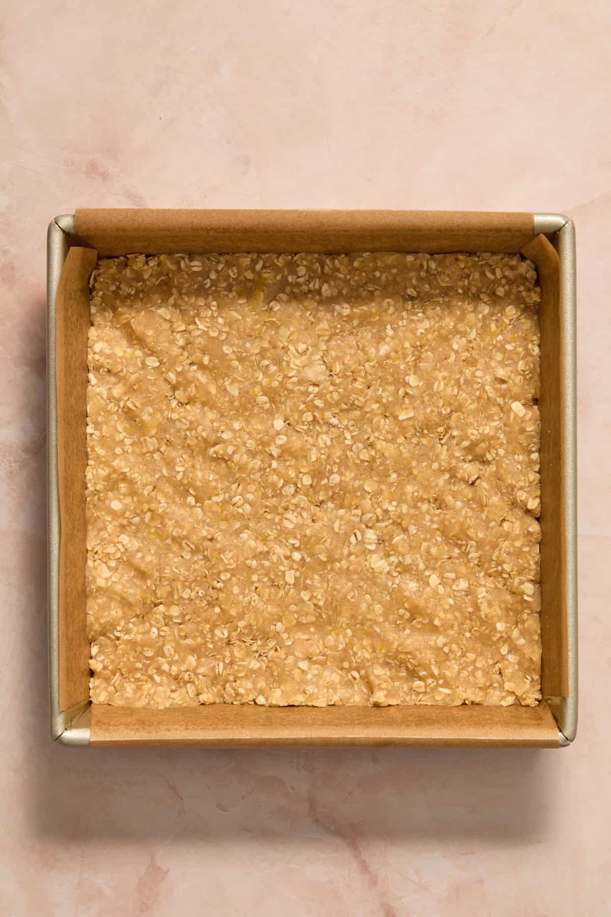 Lemon oat bar mixture pressed into lined pan.
