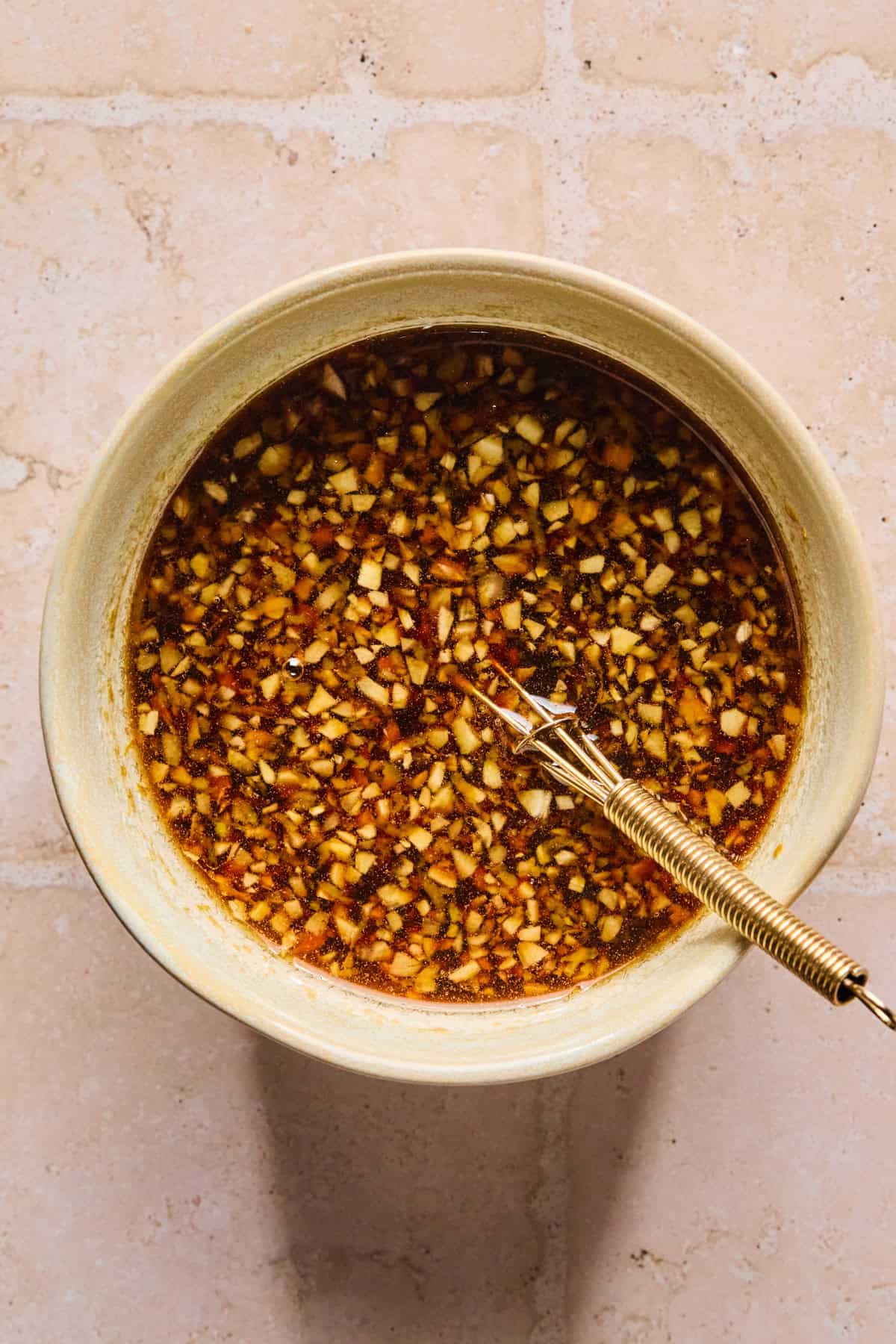 Teriyaki marinade ingredients in bowl with whisk.