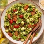 Bowl with prepared pesto tortellini salad topped with fresh chopped basil.
