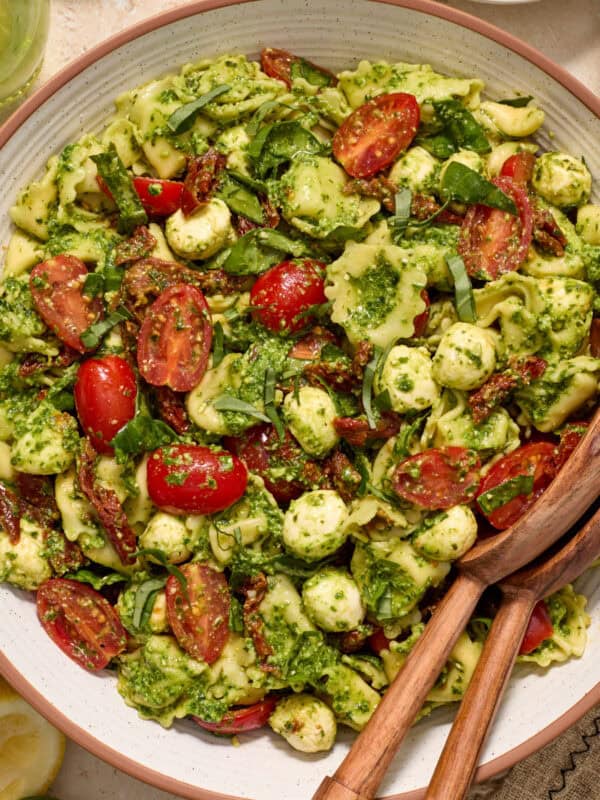 Bowl with prepared pesto tortellini salad topped with fresh chopped basil.