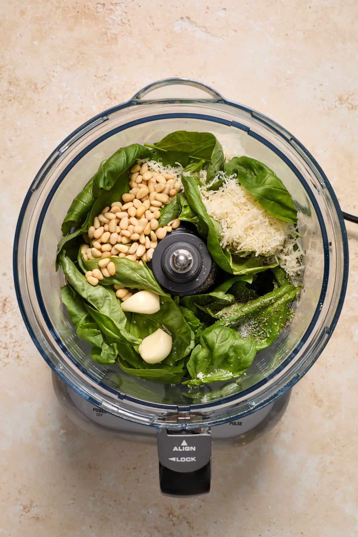 Basil, pine nuts, garlic and other ingredients added to food processor.