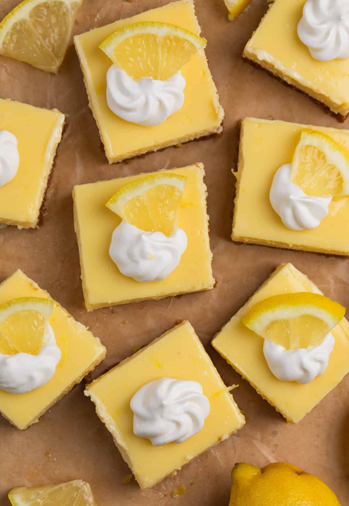 Overhead view of lemon bars topped with whipped cream.