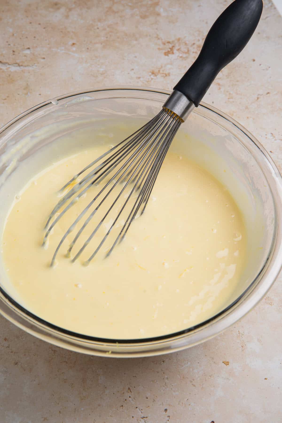 Lemon bar mixture in bowl with whisk.