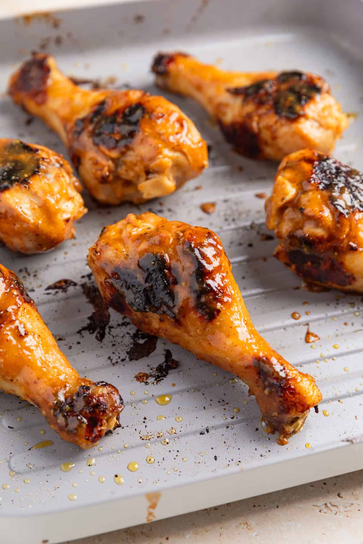 Grilled honey mustard chicken drumsticks on pan.