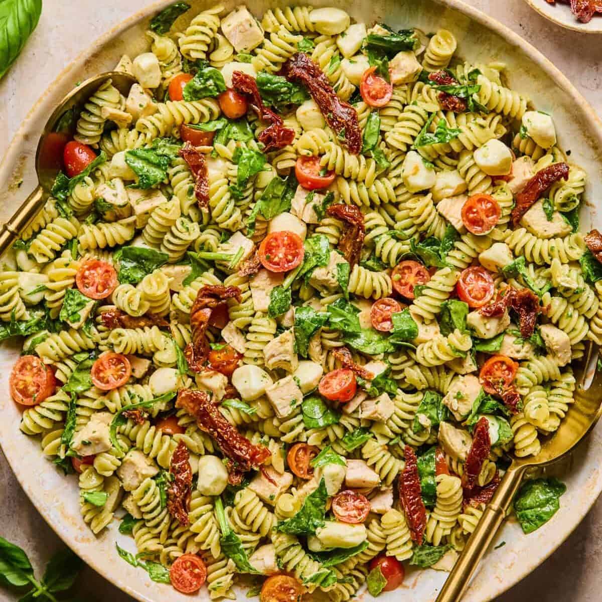Chicken pesto pasta salad prepared in bowl.