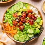 Teriyaki salmon bites in bowl with rice and vegetables.