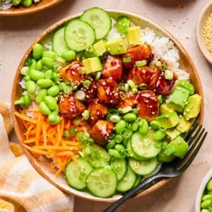 Teriyaki salmon bites in bowl with rice and vegetables.