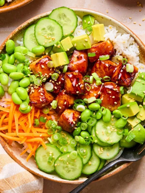 Teriyaki salmon bites in bowl with rice and vegetables.