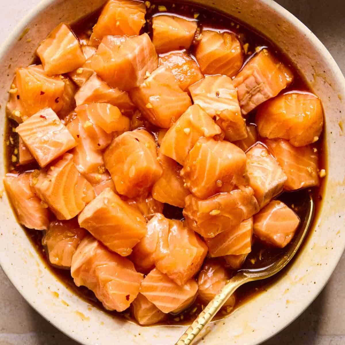 Bowl with cubed salmon in teriyaki marinade.
