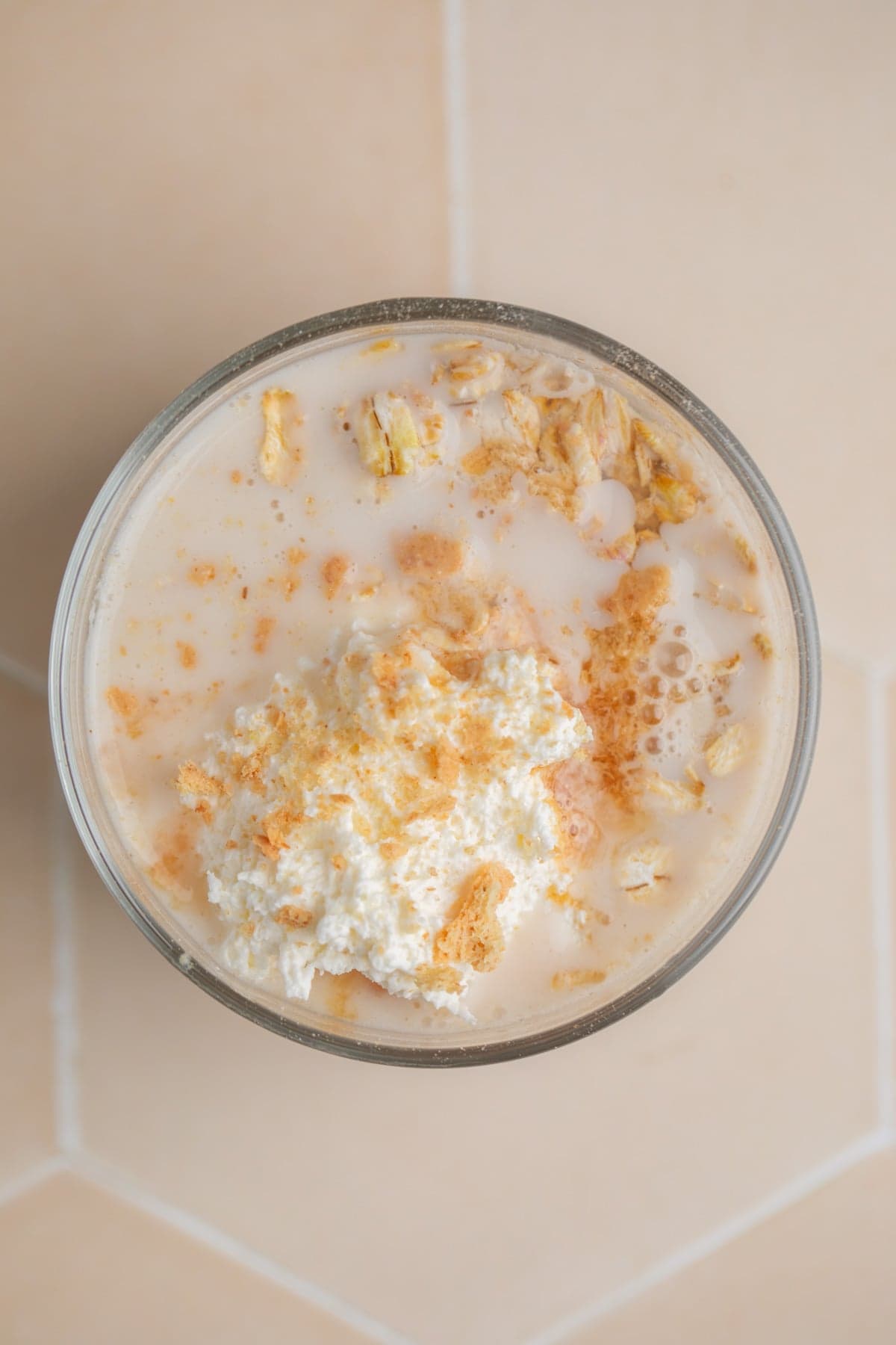 Overnight oatmeal mixture in glass jar before mixing.