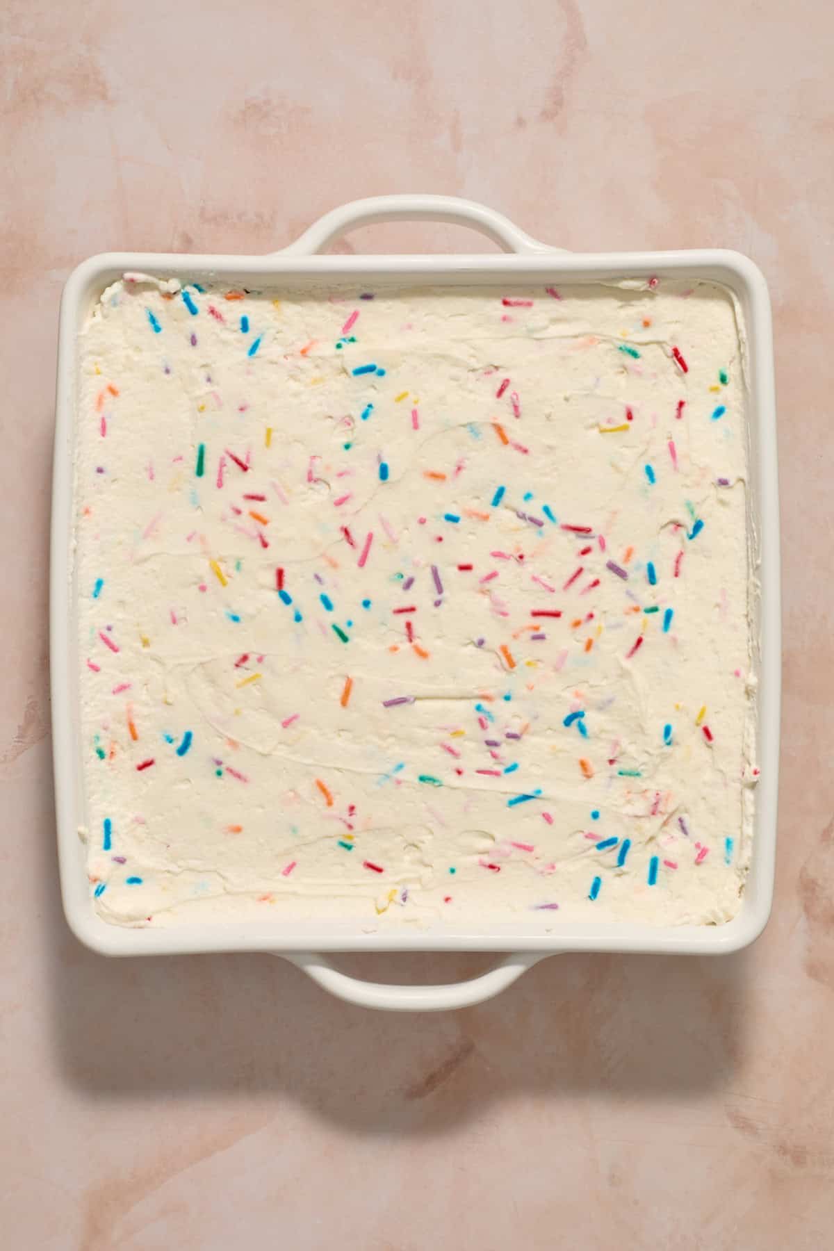 Chilled no-bake funfetti cake in white pan.