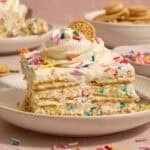 Slice of funfetti icebox cake topped with whipped cream and sprinkles.