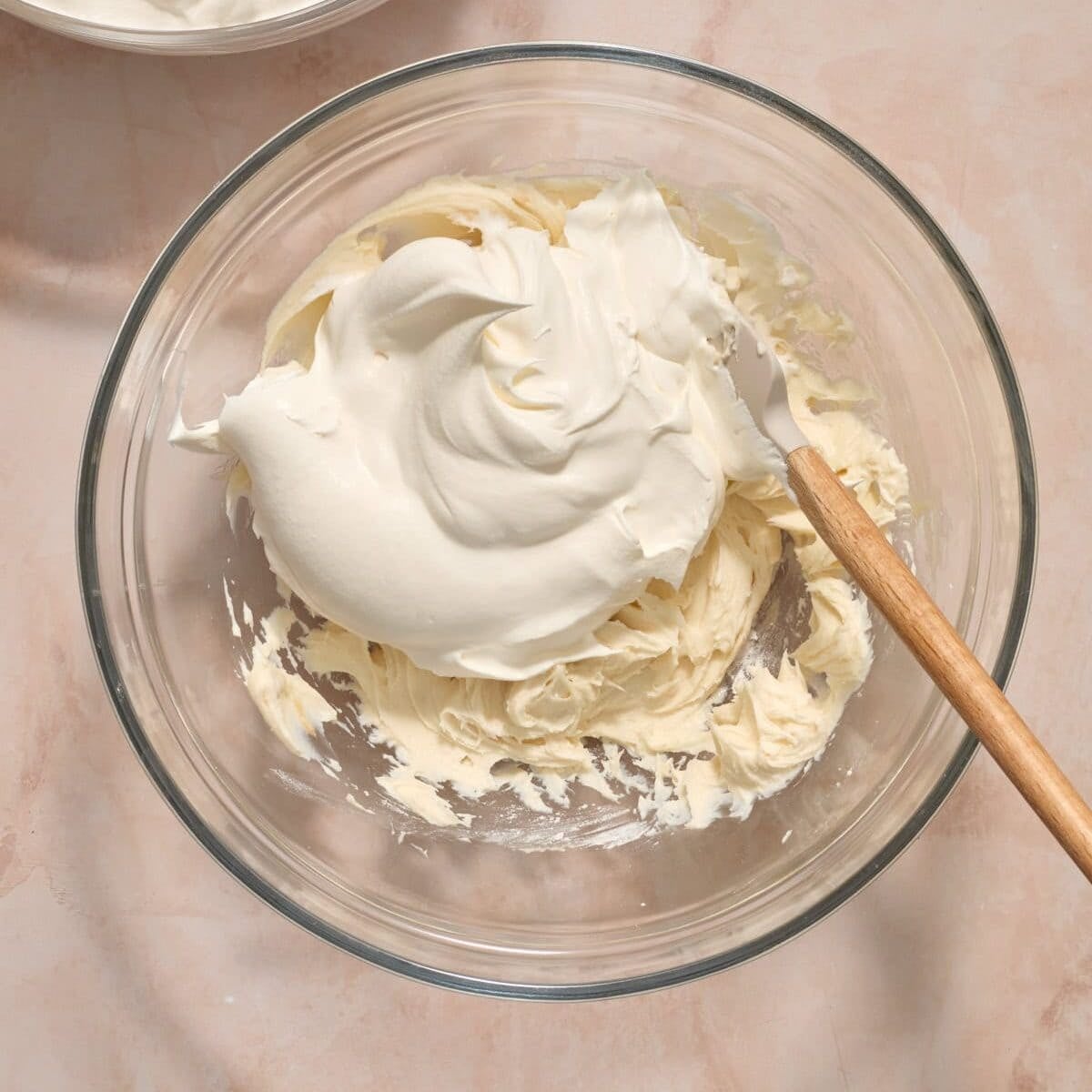 Cool whip added to cream cheese mixture in mixing bowl.