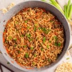 Pan with ground beef ramen topped with green onions.
