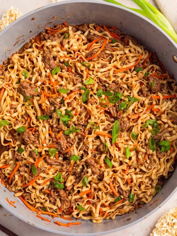 Pan with ground beef ramen topped with green onions.