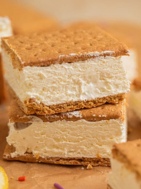 Lemonade ice cream sandwiches stacked on top of each other on parchment.