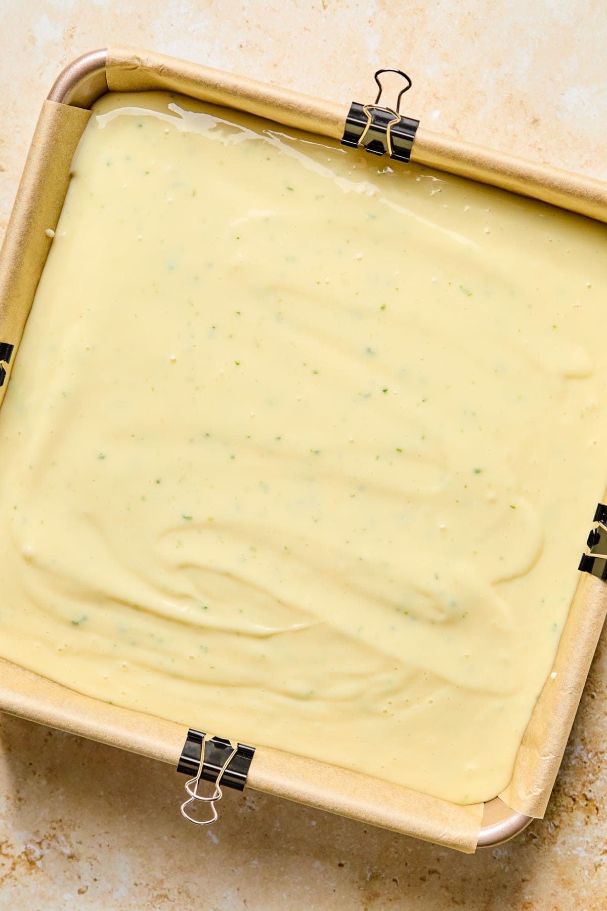 Square baking pan with creamy margarita bar mixture before baking.