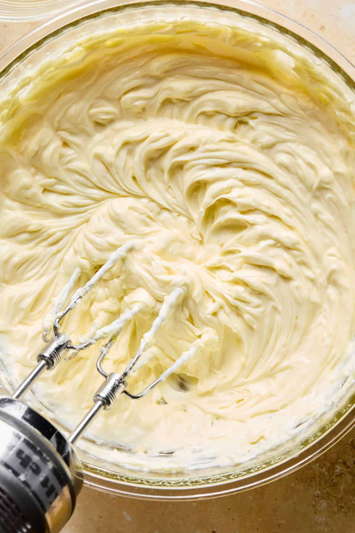 Lemon cheesecake mixture with hand mixer above.