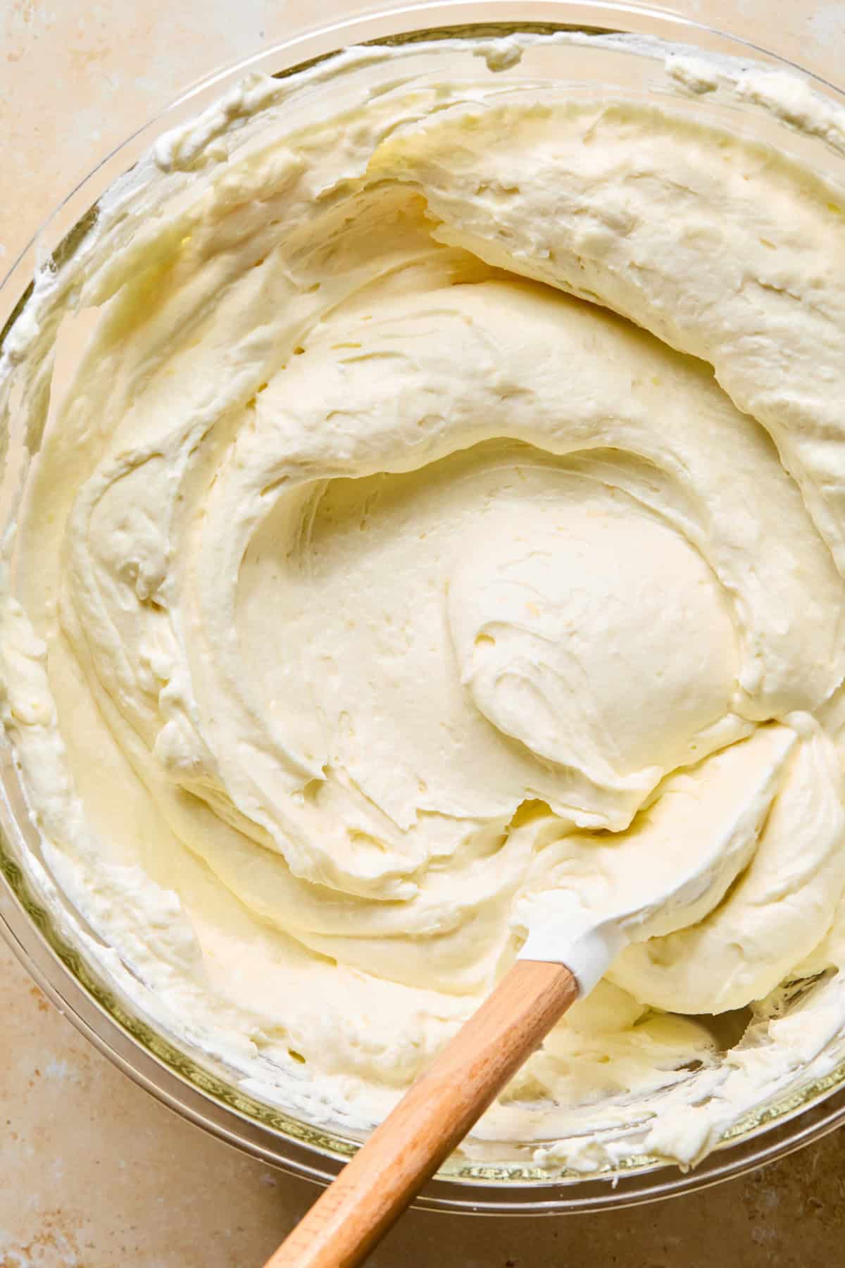No-bake lemon cheesecake mixture with spatula in bowl.