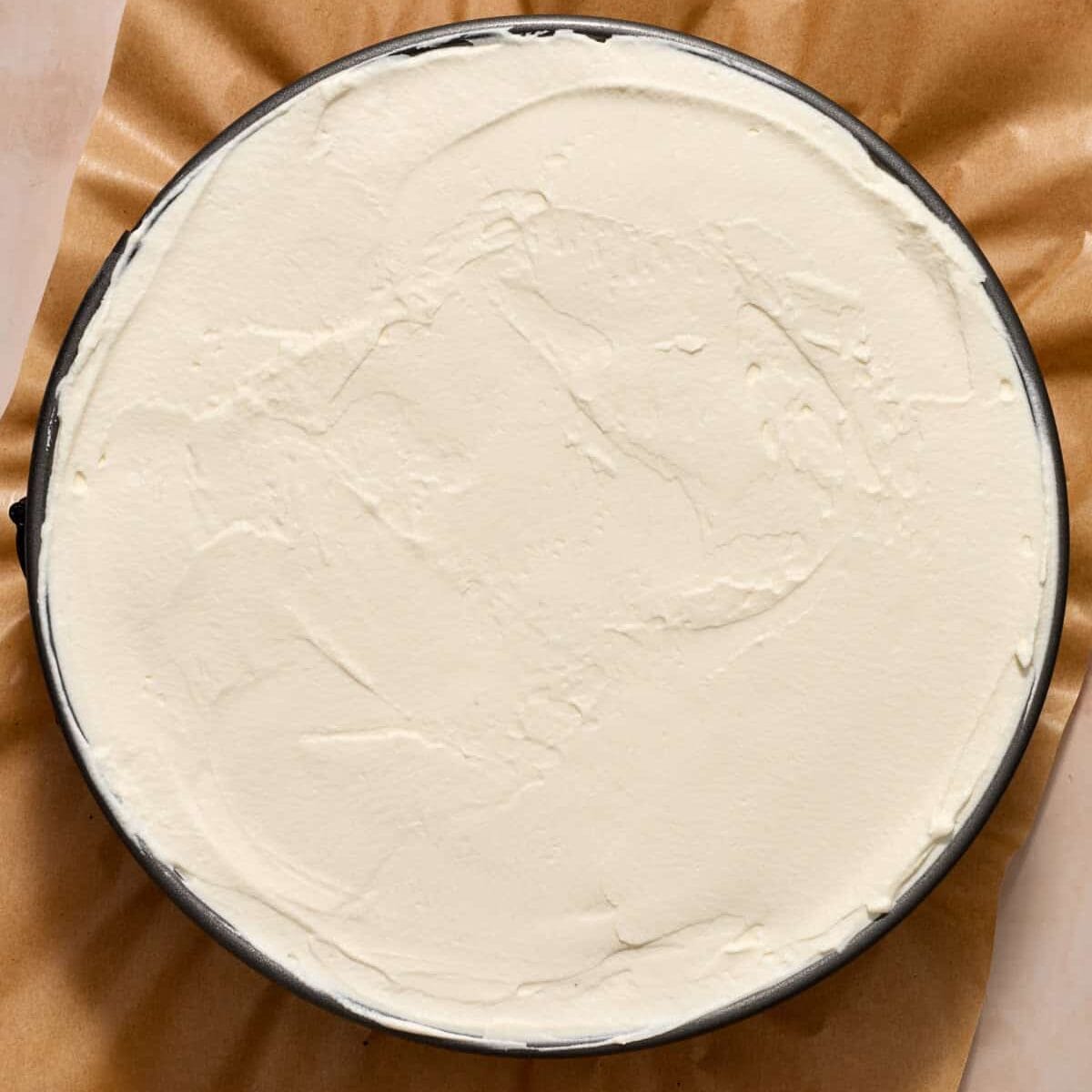 Whipped cream covered ice cream pie in pan.