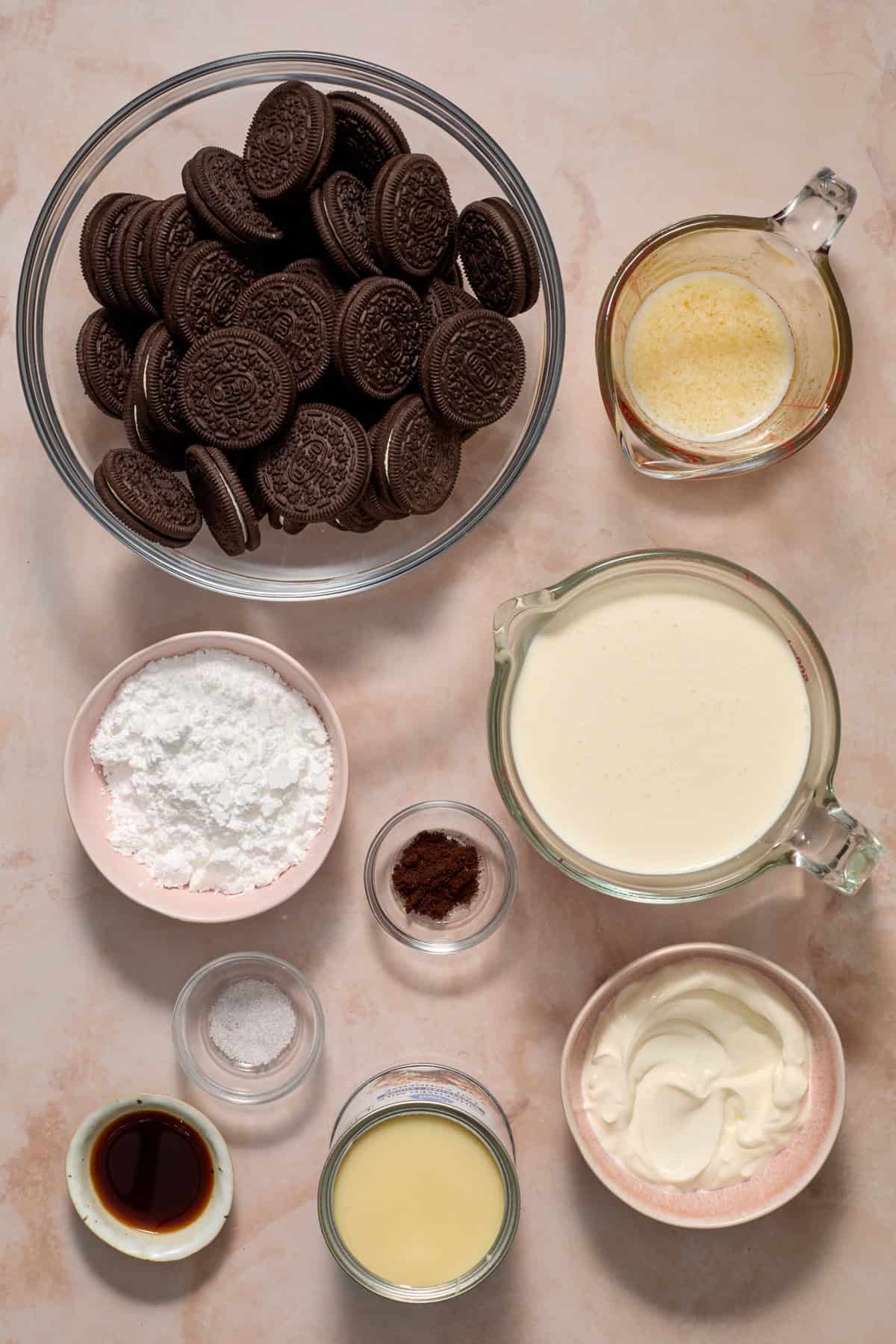 Cookies, powdered sugar, butter, cream and other ingredients on surface.